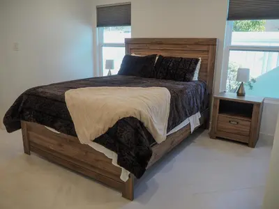 a bedroom with a large wooden bed with a night stand at Luxury 3BR, 2BA Newly Renovated with Huge Backyard in San Diego