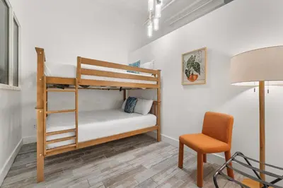 a room with two bunk beds and a chair at Downtown Gaslamp Getaway Stylish 4BR APT in San Diego