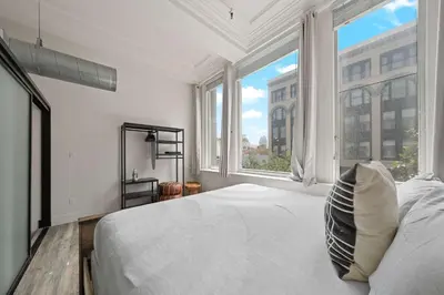 a white bedroom with a bed and a large window at Central Downtown Apt Sleeps 8 & Enjoy Gaslamp in San Diego