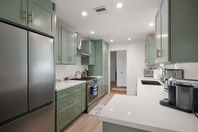 a kitchen with green cabinets and white counter tops at Water & Downtown Views Close to beach Villa in San Diego