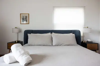 a bedroom with a bed with white sheets and pillows at Water & Downtown Views Close to beach Villa in San Diego