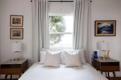 a bedroom with a bed with white pillows and a window at Water & Downtown Views Close to beach Villa in San Diego
