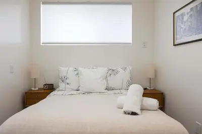 a bedroom with a bed with white sheets and a window at Water & Downtown Views Close to beach Villa in San Diego