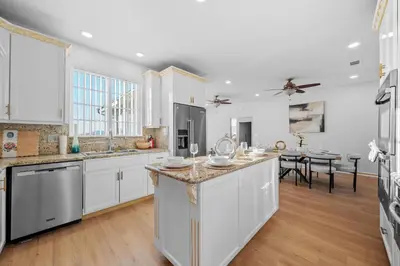 a large kitchen with white cabinets and a dining room at Entire Private Home with 4 Bedrooms 2 Bathrooms, Pool, View, 4 Parking, King Bed, Big Yard, Available Now in El Cajon
