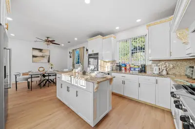 a kitchen with white cabinets and a table at Entire Private Home with 4 Bedrooms 2 Bathrooms, Pool, View, 4 Parking, King Bed, Big Yard, Available Now in El Cajon