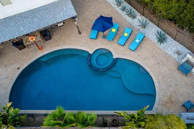 an overhead view of a swimming pool with chairs and an umbrella at Entire Private Home with 5 Bedrooms 4 Bathrooms 3000 Sq ft Villa, Pool, Hot Tub, Nature, Garage, Winery, Available Now in Fallbrook