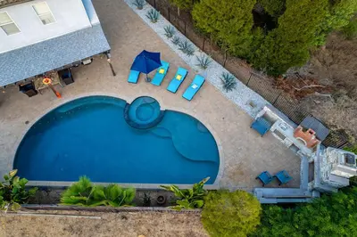 an overhead view of a swimming pool with chairs and umbrellas at Entire Private Home with 5 Bedrooms 4 Bathrooms 3000 Sq ft Villa, Pool, Hot Tub, Nature, Garage, Winery, Available Now in Fallbrook