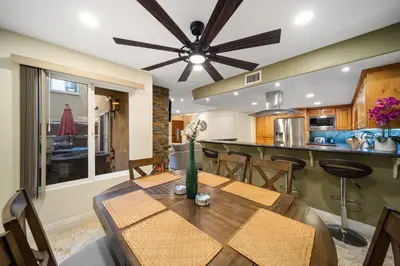 a dining room and kitchen with a table and a ceiling fan at Steps to Sand - Pacific Beach 3BR Townhome in San Diego