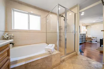 a bathroom with a tub and a glass shower at Steps to Sand - Pacific Beach 3BR Townhome in San Diego