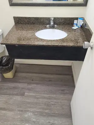 a bathroom counter with a sink and a mirror at Relax Inn And Suites in El Cajon