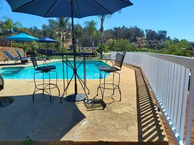 a table and chairs with an umbrella next to a pool at Stylish Relaxation-Panoramic Views-Private OASIS in El Cajon