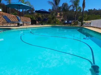 a large blue swimming pool with chairs and an umbrella at Stylish Relaxation-Panoramic Views-Private OASIS in El Cajon