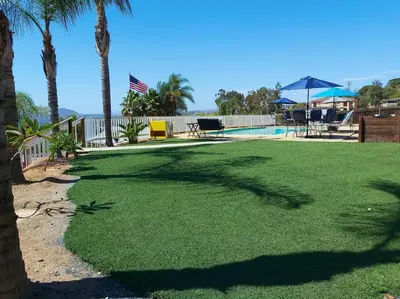 a lawn with palm trees and a swimming pool at Stylish Relaxation-Panoramic Views-Private OASIS in El Cajon