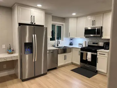 a kitchen with white cabinets and a stainless steel refrigerator at 321 W Park 2Bed 1Bath Unit A by SD Stay in El Cajon