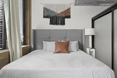 a bedroom with a large white bed with a brown pillow at Party in Gaslamp 4BR Downtown Pad with Bathtub in San Diego