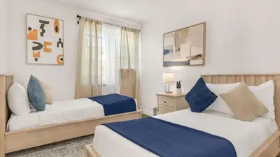 a bedroom with two beds with blue and white at Hot Tub • BBQ Island • Outdoor Living • Near San Diego Beaches Glidden Glow by AvantStay in San Diego