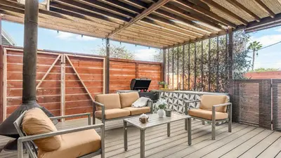 a patio with two chairs and a table on a deck at Hot Tub • BBQ Island • Outdoor Living • Near San Diego Beaches Glidden Glow by AvantStay in San Diego