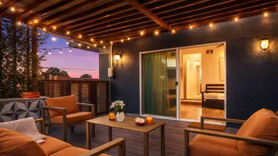 a patio with a couch and chairs and lights at Hot Tub • BBQ Island • Outdoor Living • Near San Diego Beaches Glidden Glow by AvantStay in San Diego
