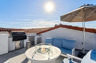 a patio with a table and chairs and an umbrella at Walk to Pier and Downtown San Clemente Rooftop Deck in San Clemente