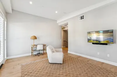 a white living room with a white chair and a table at Walk to Pier and Downtown San Clemente Rooftop Deck in San Clemente
