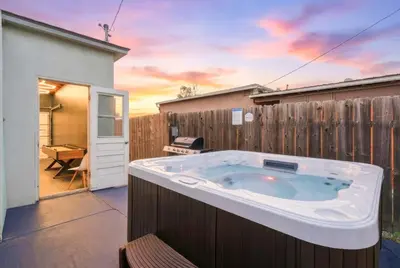 a hot tub in a backyard with a fence at 3BR Modern Chula Vista Home with Hot Tub and Game Room in Chula Vista