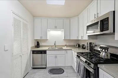 a kitchen with white cabinets and a stove top oven at 3BR Modern Chula Vista Home with Hot Tub and Game Room in Chula Vista