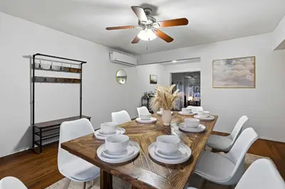 a dining room with a wooden table and white chairs at 3BR Modern Chula Vista Home with Hot Tub and Game Room in Chula Vista