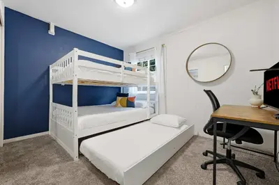 a bedroom with two bunk beds and a desk at 3BR Modern Chula Vista Home with Hot Tub and Game Room in Chula Vista