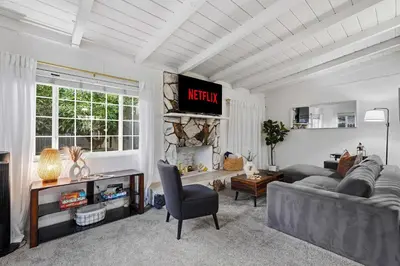 a living room with a gray couch and a tv at 3BR Modern Chula Vista Home with Hot Tub and Game Room in Chula Vista
