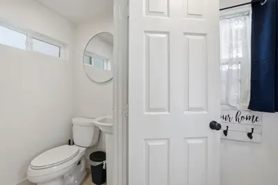 a white bathroom with a toilet and a mirror at NEW Oceanfront Luxury Christian RARE Single Family Home in San Diego