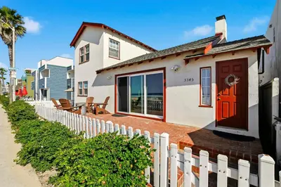 a white house with a red door and a fence at NEW Oceanfront Luxury Christian RARE Single Family Home in San Diego