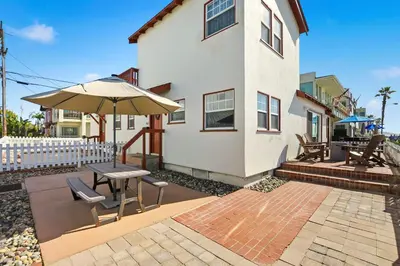a house with a patio with a table and an umbrella at NEW Oceanfront Luxury Christian RARE Single Family Home in San Diego
