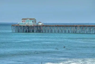 a pier with a house on it in the water at Monarch Cove - Unit C For 4ppl in Oceanside