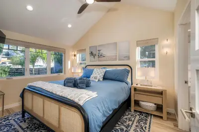 a bedroom with a bed with blue sheets and a table at Monarch Cove - Unit A For 7ppl in Oceanside