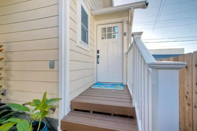a white door on a house with a wooden staircase at Monarch Cove - Unit B For 2ppl in Oceanside