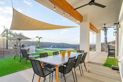 a dining room with a table and chairs on a patio at Vista Oasis with Spa, Pool, & Views in Vista