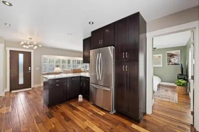 a kitchen with wooden cabinets and a stainless steel refrigerator at Mt. Helix Resort+ Pool/Spa, Pickleball, Amenities! in La Mesa
