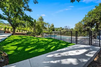 a fence with a yard of grass and a pool at Mt. Helix Resort+ Pool/Spa, Pickleball, Amenities! in La Mesa