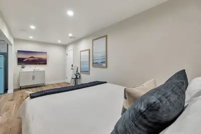 a bedroom with white walls and a large bed at ON Avenida Del Mar Heart of Downtown 10 minute WALK to the Pier Parking in San Clemente