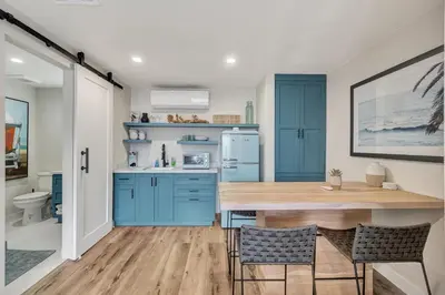 a kitchen with blue cabinets and a wooden table at ON Avenida Del Mar Heart of Downtown 10 minute WALK to the Pier Parking in San Clemente