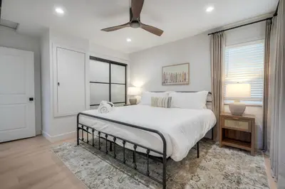 a bedroom with a large bed and a ceiling fan at Modern Ocean-View Retreat w/ Firepit & Steps to Carlsbad Beach in Carlsbad