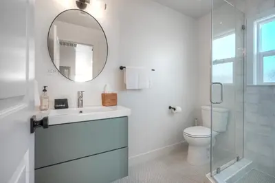 a white bathroom with a sink and a mirror at Modern Ocean-View Retreat w/ Firepit & Steps to Carlsbad Beach in Carlsbad