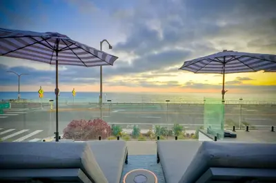 a view of the ocean from a restaurant with umbrellas at Sycamore Haus Estate – Rent All 3 Ocean-View Luxury Condos Steps from Carlsbad State Beach in Carlsbad