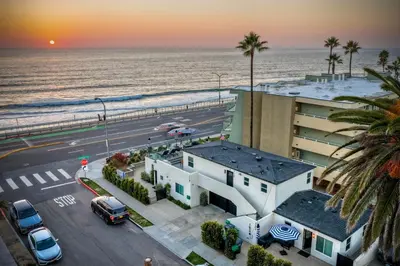 an aerial view of a building and the beach at Sycamore Haus Estate – Rent All 3 Ocean-View Luxury Condos Steps from Carlsbad State Beach in Carlsbad