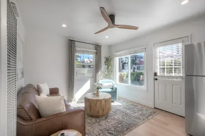 a living room with a couch and a ceiling fan at Modern Carlsbad Vacation Rental with Ocean Views, Private Patio, Fire Pit & Walkable Location in Carlsbad