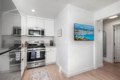 a kitchen with stainless steel appliances and white cabinets at Modern Carlsbad Vacation Rental with Ocean Views, Private Patio, Fire Pit & Walkable Location in Carlsbad