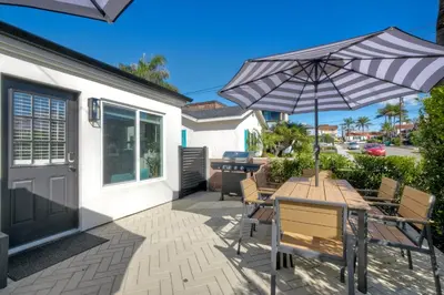 a patio with a table and an umbrella at Modern Carlsbad Vacation Rental with Ocean Views, Private Patio, Fire Pit & Walkable Location in Carlsbad