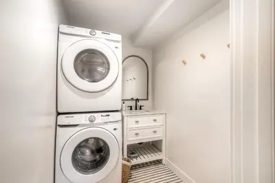 a laundry room with a washer and dryer at Modern Carlsbad Vacation Rental with Ocean Views, Private Patio, Fire Pit & Walkable Location in Carlsbad