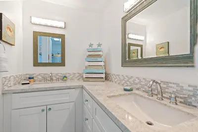a bathroom with two sinks and a mirror at Stunning Oceanview Penthouse | 2BR, Sleeps 6 | North Coast Village Resort in Oceanside