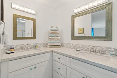a bathroom with two sinks and two mirrors at Stunning Oceanview Penthouse | 2BR, Sleeps 6 | North Coast Village Resort in Oceanside